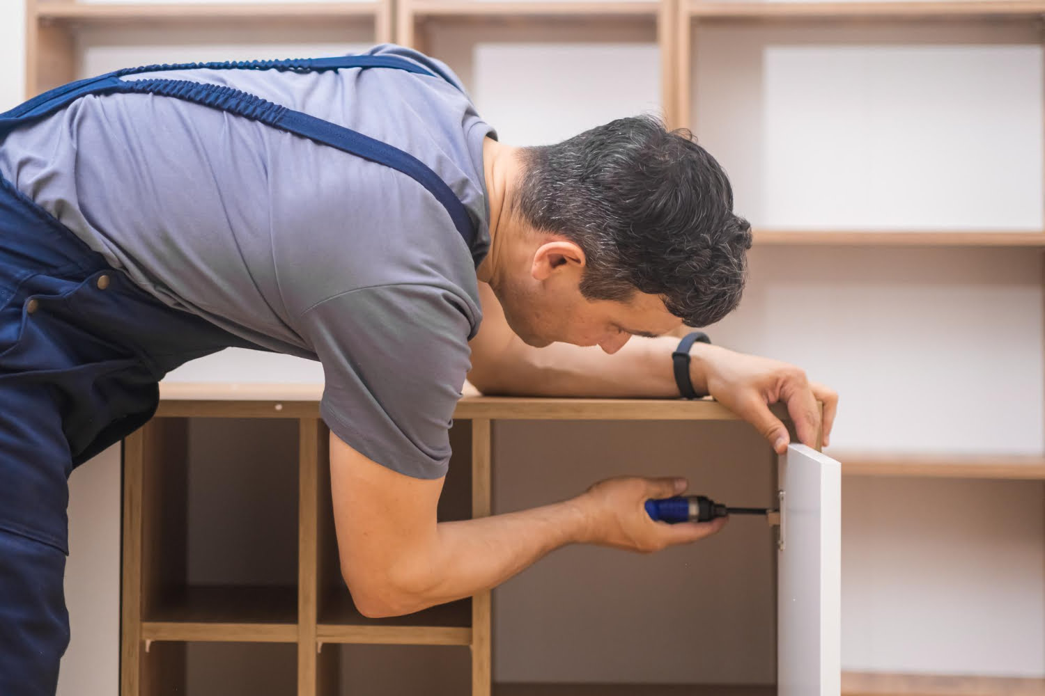 furniture-fixing-services-professional-worker-uniform-screwing-nail-into-panel-made-wood